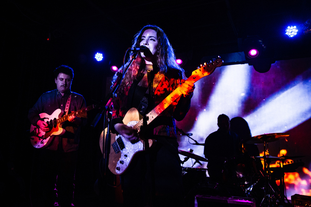 Musical Band Playing Music on Stage With Purple and White Lights